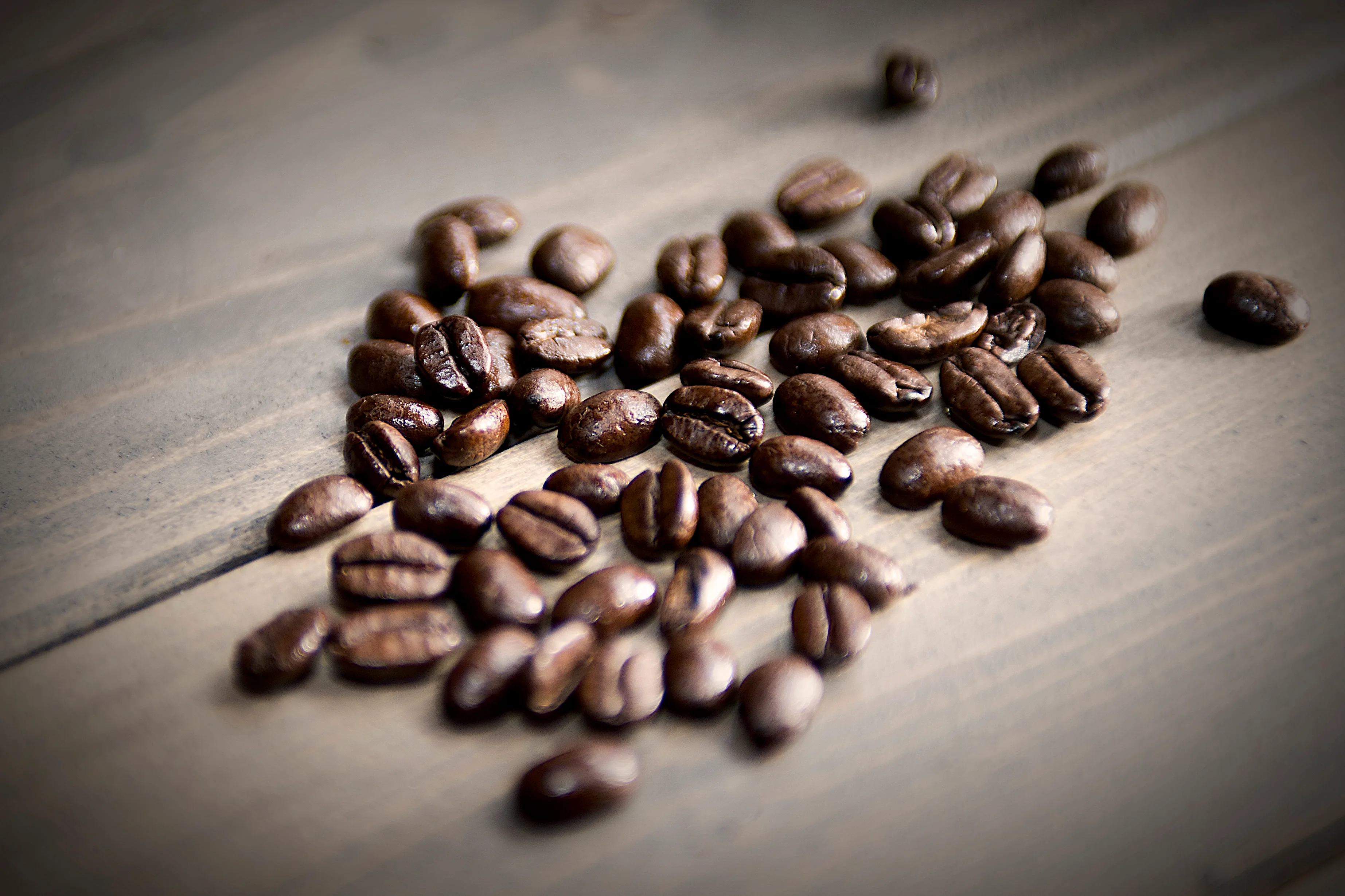 Röstkaffeebohnen auf einer Tischplatte, Pressefoto des Deutschen Kaffeeverbands